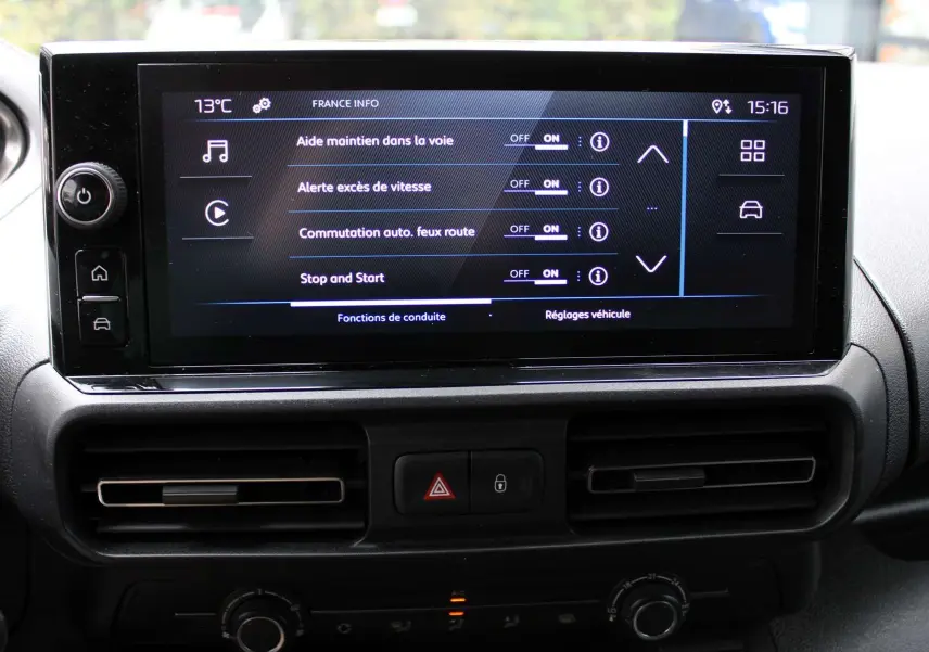 Écran tactile central affichant les aides à la conduite dans l'habitacle du Peugeot Partner Fourgon blanc 2025.