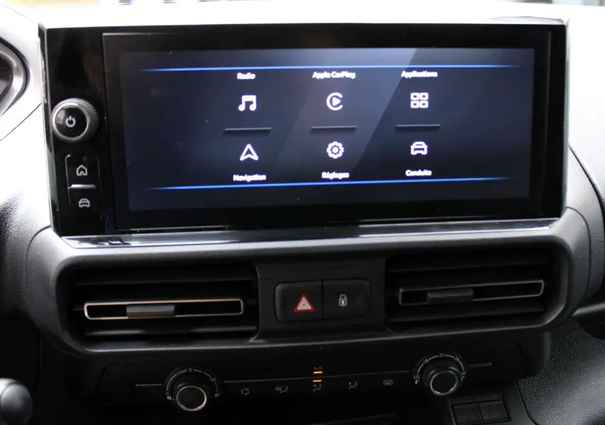 Écran tactile central allumé avec menus radio, navigation et réglages dans l'habitacle du Peugeot Partner Fourgon blanc 2025.