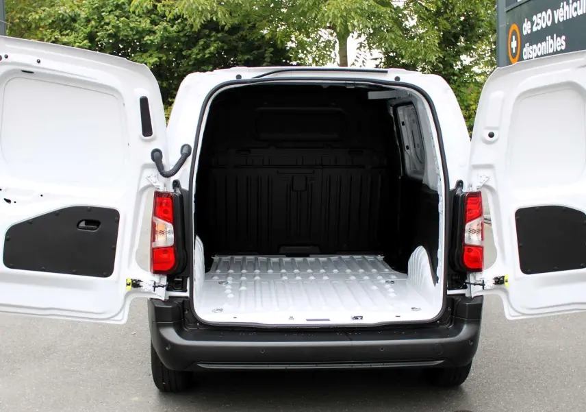 Vue arrière du Peugeot Partner Fourgon blanc 2025 avec portes arrière ouvertes montrant l'espace de chargement vide.