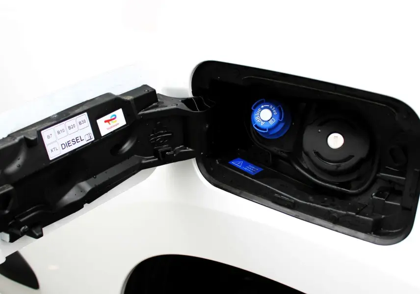 Bouchon de réservoir AdBlue bleu et bouchon diesel noir sur le côté gauche d'un Peugeot Partner Fourgon blanc 2025.