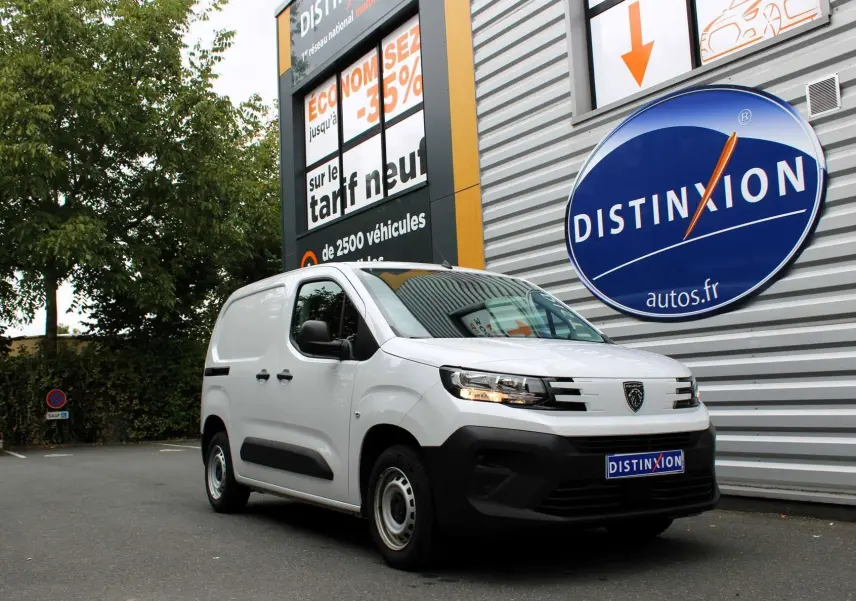 Peugeot Partner Fourgon blanc vu en 3/4 avant droit, stationné devant un mur avec logo Distinxion.