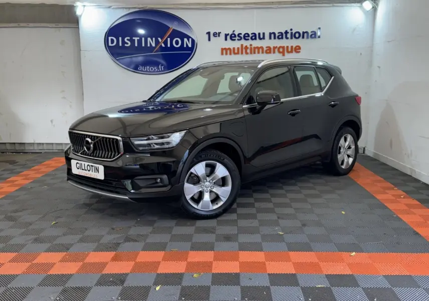 Volvo XC40 Recharge T5 noir en 3/4 avant droit dans un showroom avec sol à damiers gris et orange.