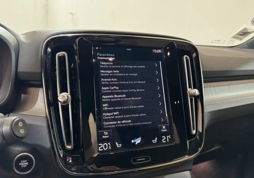 Vue intérieure centrée sur l'écran tactile 9 pouces du tableau de bord du Volvo XC40 noir, avec commandes climatisation visibles.