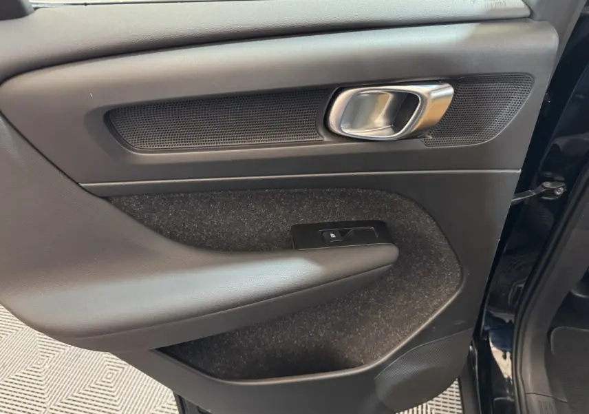 Vue intérieure du panneau de porte avant droit noir du Volvo XC40 Recharge T5 2021 avec poignée alu et commande de verrouillage.