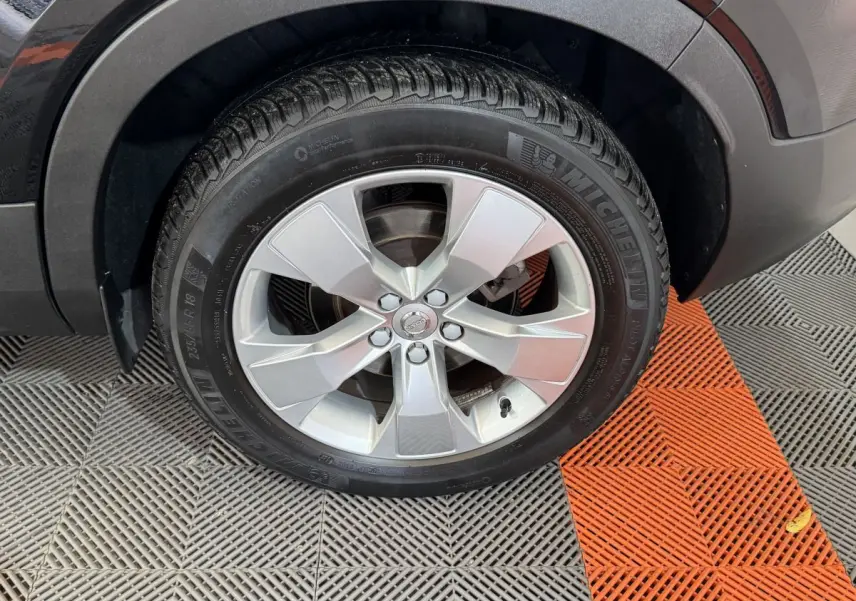 Gros plan sur la roue avant droite avec jante argentée du Volvo XC40 noir Recharge T5 Inscription 2021.