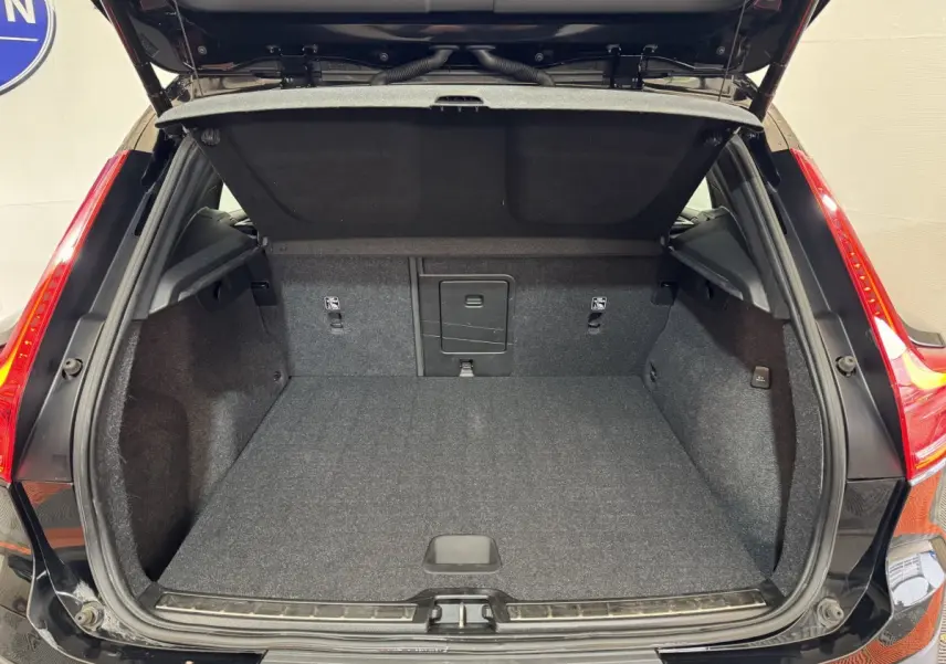 Coffre ouvert vu de l'arrière d'un Volvo XC40 noir, montrant un espace de chargement propre et spacieux.