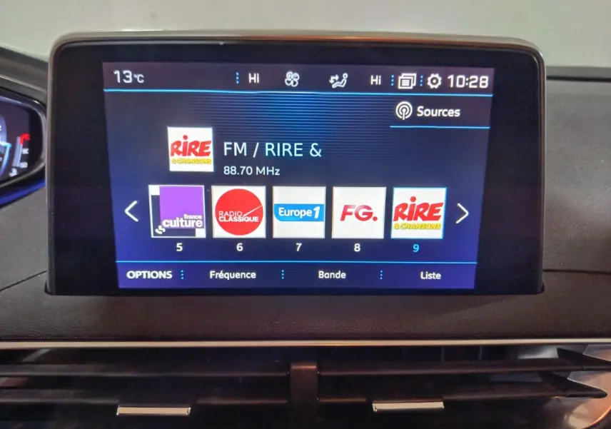 Écran tactile central affichant les radios FM dans l’habitacle du Peugeot 3008 marron, vue de face rapprochée.