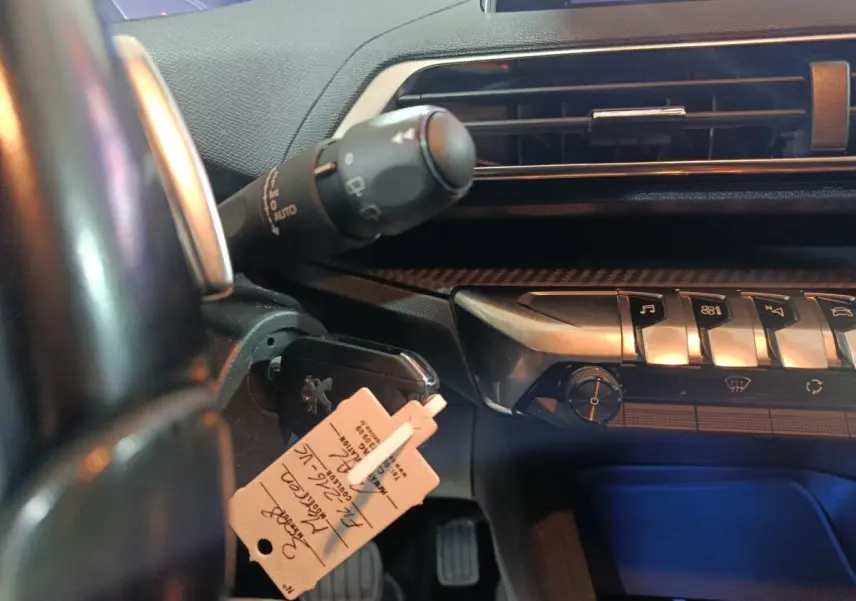 Vue rapprochée du tableau de bord côté conducteur d’un Peugeot 3008 marron, avec commandes et clé insérée.