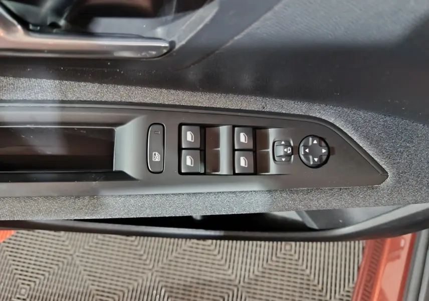 Vue rapprochée de la commande des vitres électriques sur la porte côté conducteur du Peugeot 3008 marron 2019.