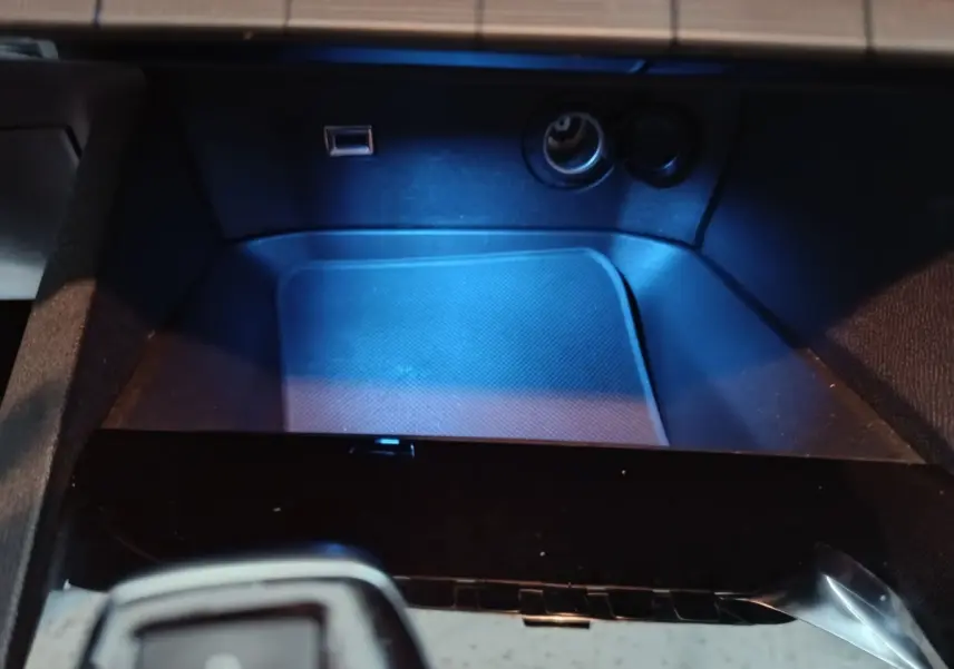 Gros plan sur la console centrale du Peugeot 3008 marron, montrant prise USB et allume-cigare avec éclairage bleu.