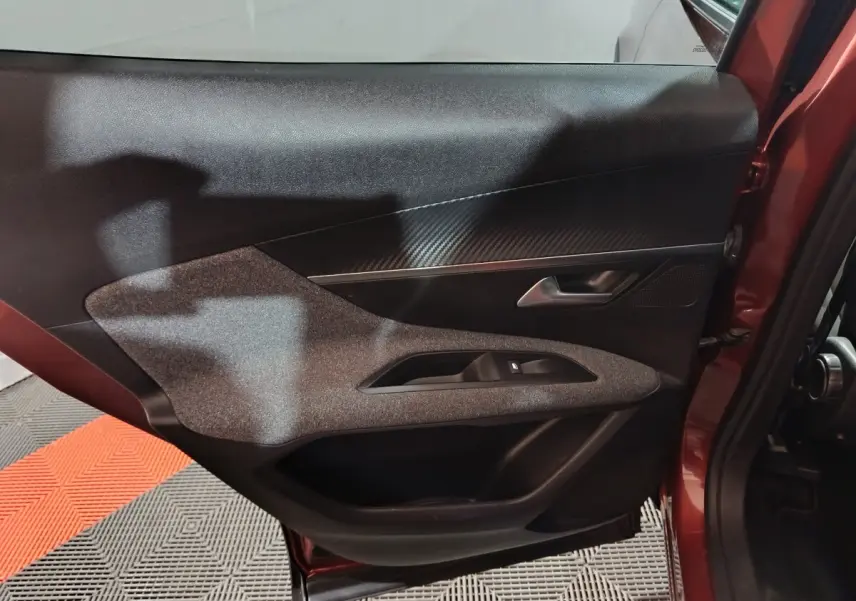 Vue intérieure côté gauche de la porte arrière marron du Peugeot 3008 avec garniture noire et insert gris texturé.
