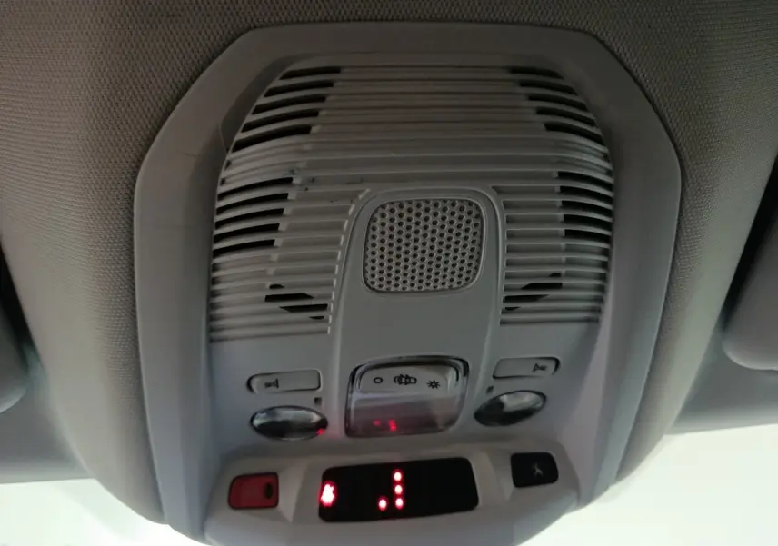 Plafonnier intérieur gris avec commandes et haut-parleur, vue en contre-plongée dans un Peugeot 3008 marron de 2019.
