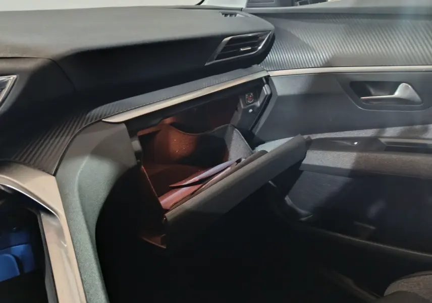 Intérieur Peugeot 3008 2019 marron, vue de la boîte à gants ouverte côté passager avec tableau de bord texturé.