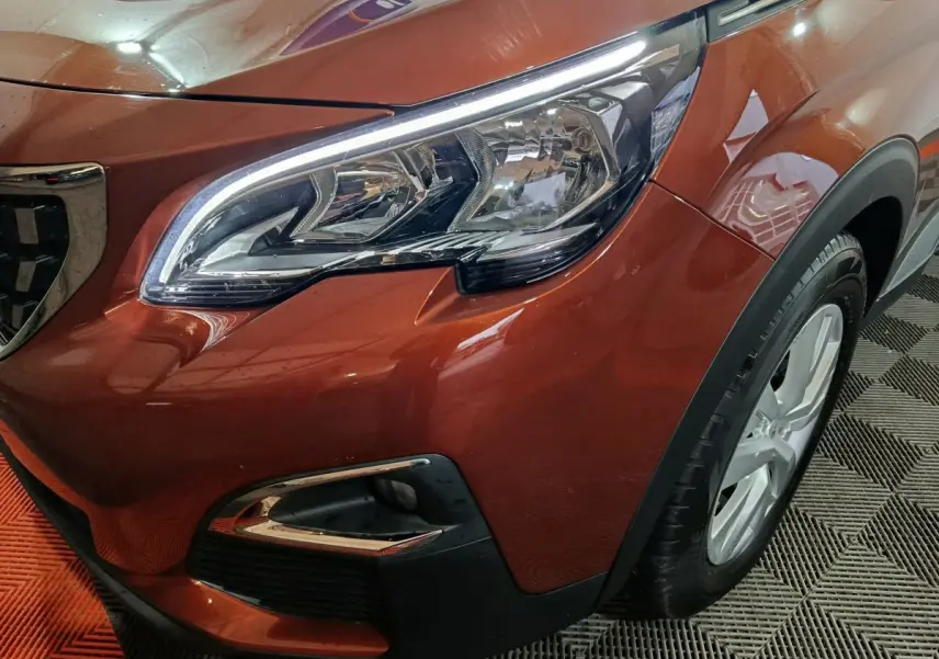 Gros plan sur l'avant droit marron du Peugeot 3008 2019, mettant en valeur le phare et la calandre chromée.