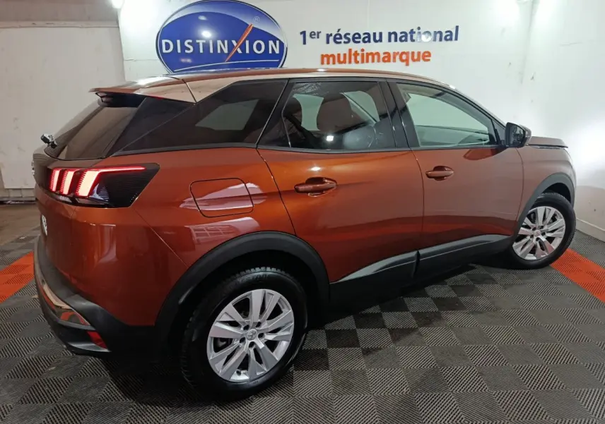 Peugeot 3008 marron vue 3/4 arrière droit, feux arrière LED allumés, toit noir et jantes argentées.