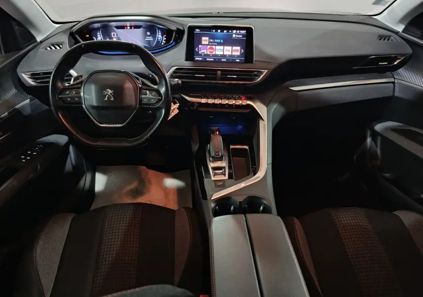 Vue intérieure frontale du tableau de bord et volant cuir du Peugeot 3008, avec écran tactile central allumé.