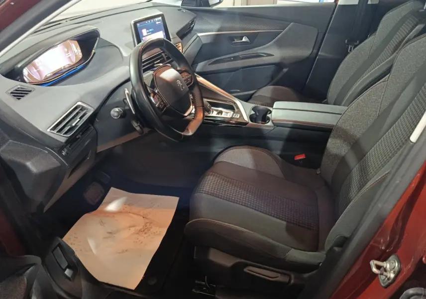Vue intérieure côté conducteur du Peugeot 3008 2019, montrant le tableau de bord et les sièges en tissu gris.
