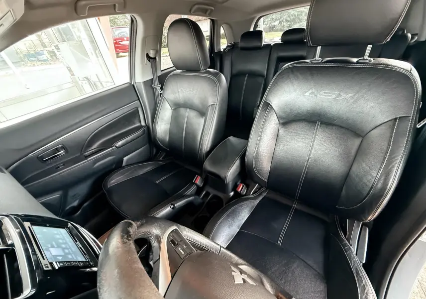 Vue intérieure avant du Mitsubishi ASX 2015 montrant les sièges en cuir noir avec logo ASX brodé.