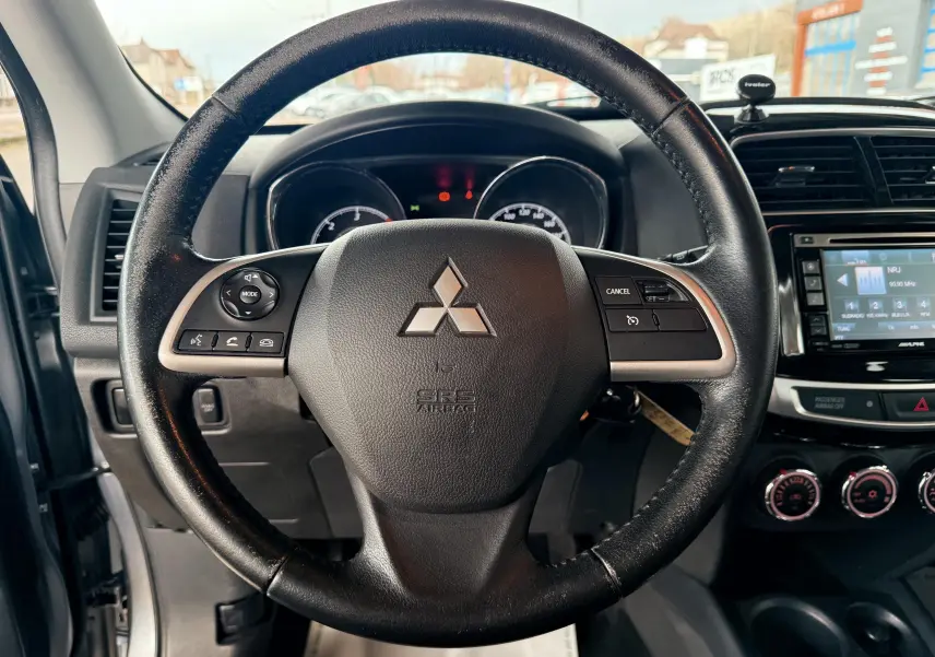 Vue centrée sur le volant noir du Mitsubishi ASX 2015 avec tableau de bord et console centrale visibles.