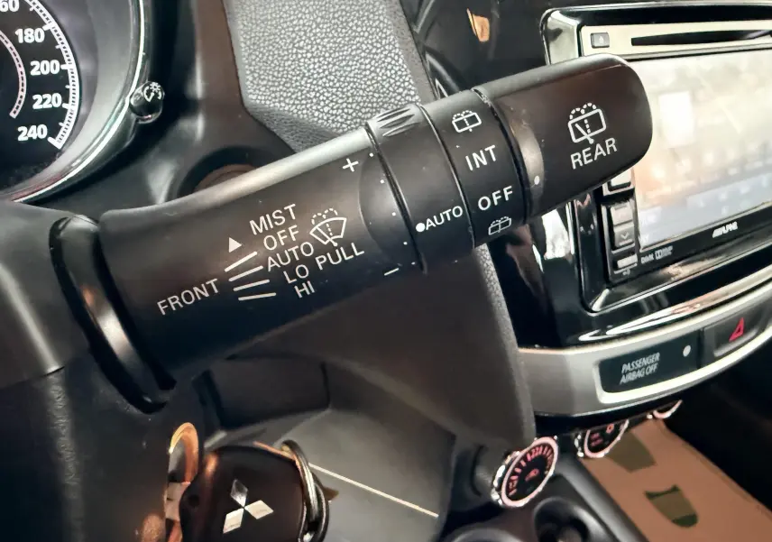 Gros plan sur la commande d’essuie-glace du Mitsubishi ASX 2015, intérieur noir avec tableau de bord et écran tactile.