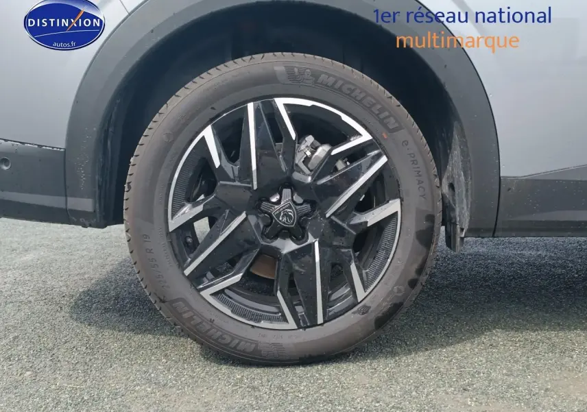 Gros plan sur la roue arrière droite du Peugeot 5008 gris artense, mettant en valeur la jante alu noire et argentée.