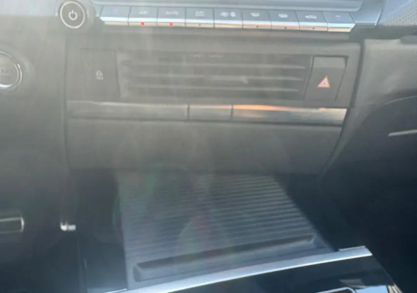 Vue intérieure centrée sur la console centrale noire de l'Opel Astra 2024 avec commandes climatisation et rangement fermé.