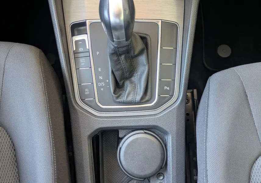 Vue plongeante sur la console centrale de la Volkswagen Golf Sportsvan noire, avec levier de vitesse DSG et porte-gobelets.