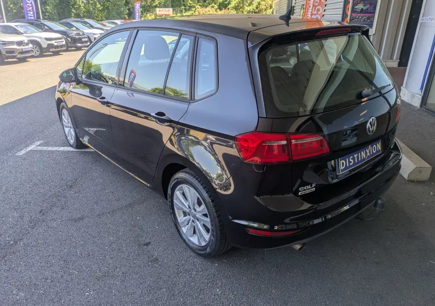 Vue 3/4 arrière droite d'une Volkswagen Golf Sportsvan noire de 2014, avec hayon fermé et jantes alliage visibles.
