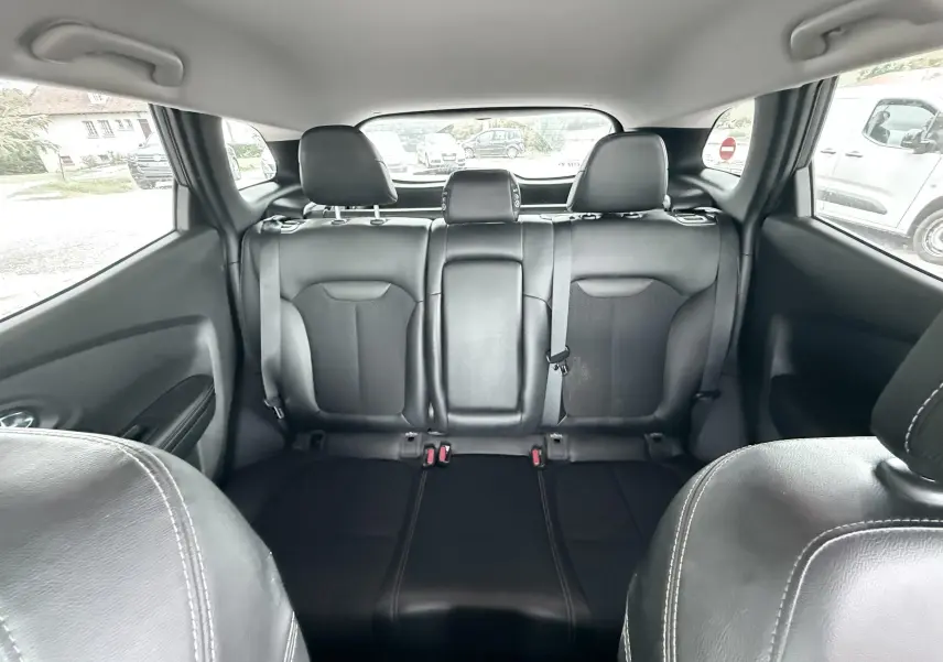 Vue intérieure arrière du Renault Kadjar 2016 montrant les sièges noirs en cuir avec appuie-têtes et ceinture de sécurité.