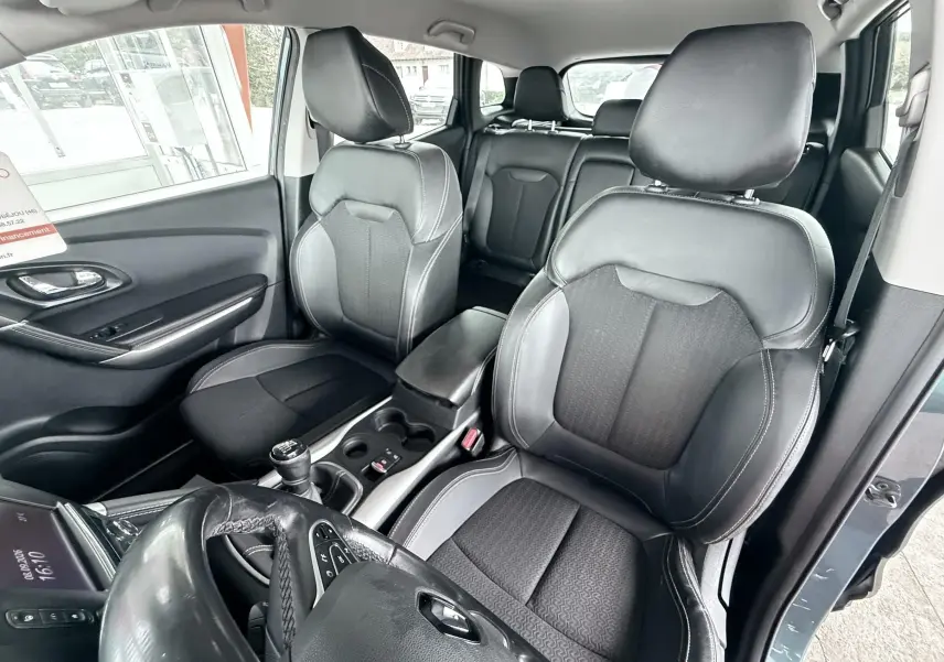Vue intérieure avant droite du Renault Kadjar 2016, sièges en cuir noir avec surpiqûres blanches et volant multifonction.