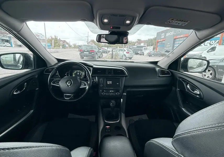 Intérieur noir du Renault Kadjar 2016, vue frontale du tableau de bord avec volant et boîte manuelle visible.