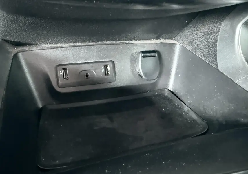 Gros plan sur la console centrale du Renault Kadjar gris, montrant deux ports USB et une prise 12V.