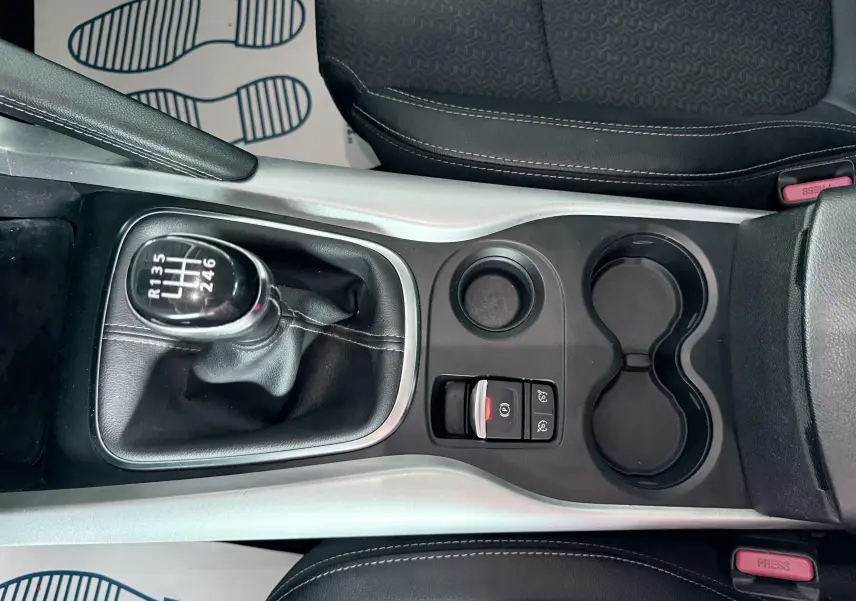 Vue plongeante sur la console centrale du Renault Kadjar gris, mettant en valeur le levier de vitesses manuel et les porte-gobelets.