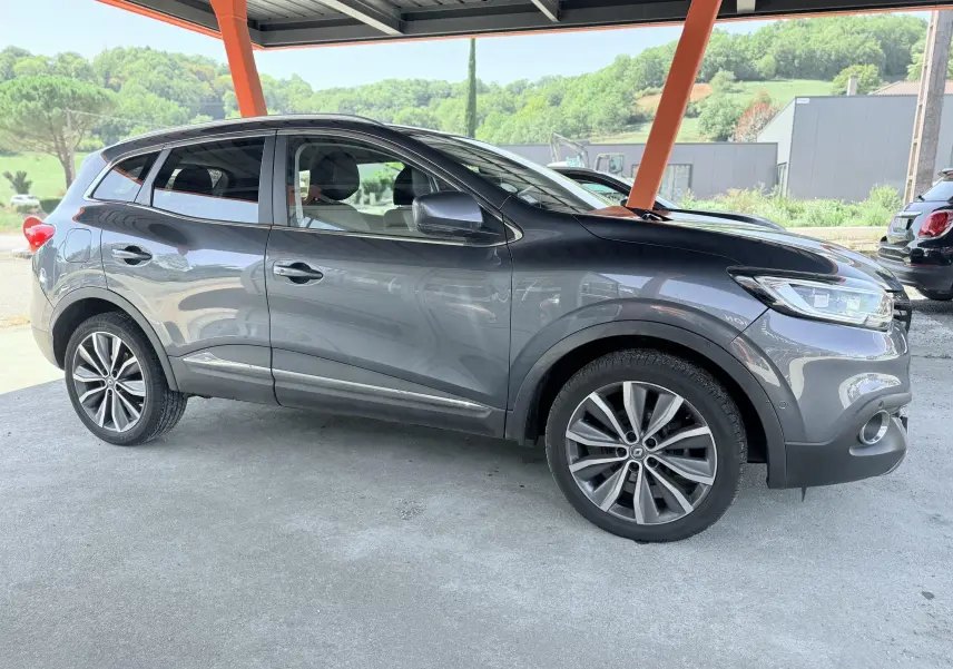 Renault Kadjar gris en vue de profil côté gauche, sous abri avec jantes alliage et lignes fluides visibles.