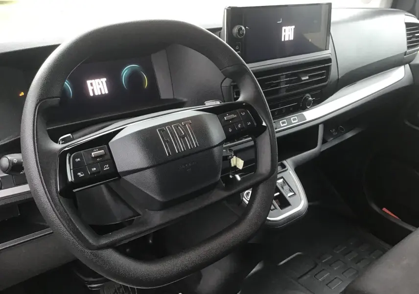 Vue intérieure du tableau de bord du Fiat Scudo Fourgon 2024, avec volant multifonction et écran tactile central allumé.