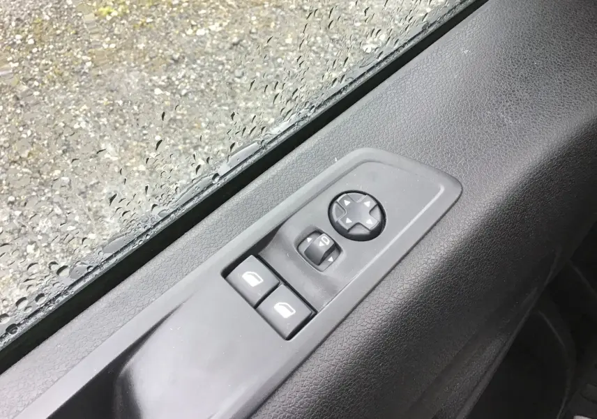 Gros plan sur les commandes de réglage des rétroviseurs et vitres côté conducteur du FIAT Scudo Fourgon blanc 2024.