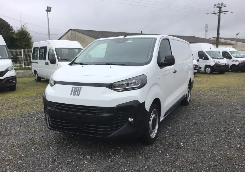 Fourgon FIAT Scudo blanc vu en 3/4 avant droit, avec pare-chocs noir et calandre moderne, stationné sur un terrain extérieur.
