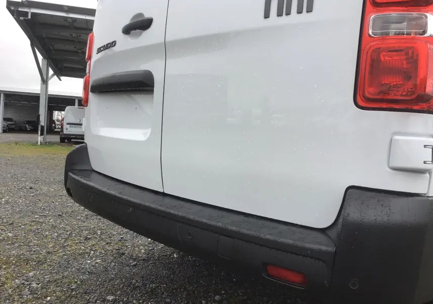 Vue rapprochée arrière droite du fourgon blanc Fiat Scudo 2024 avec pare-chocs noir et feux arrière visibles.
