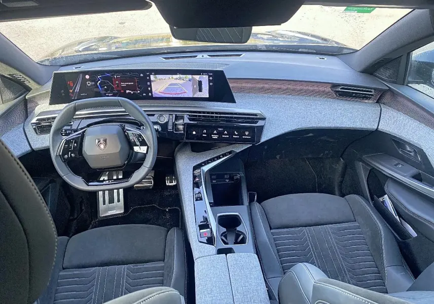 Vue intérieure avant du Peugeot 5008 Hybrid 145 GT e-dcs6 2025, tableau de bord moderne et sièges noirs avec console centrale grise.