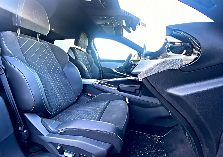 Vue intérieure côté passager avant du Peugeot 5008 Hybrid 145 GT e-dcs6 2025 avec sièges noirs et détails en tissu.