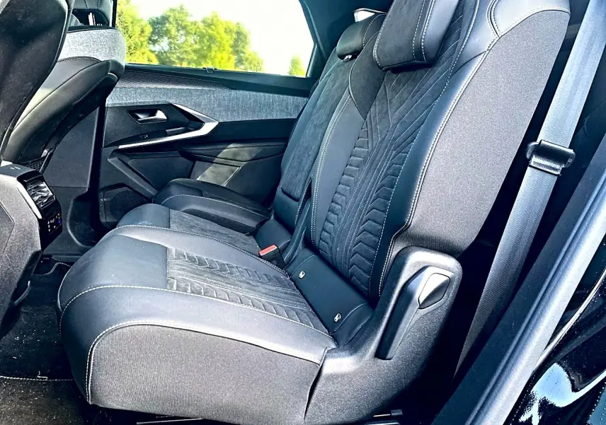 Vue latérale droite des sièges arrière noirs en tissu et cuir du Peugeot 5008 Hybrid 145 GT e-dcs6 2025, avec ceinture visible.