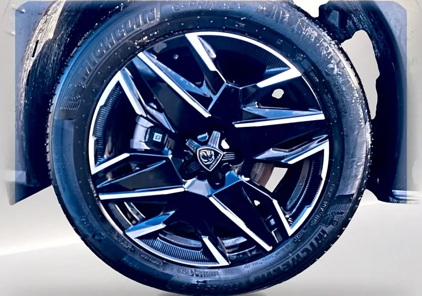Gros plan sur la jante alu noire et argentée du côté droit d’un Peugeot 5008 Hybrid 145 GT e-dcs6 noir.