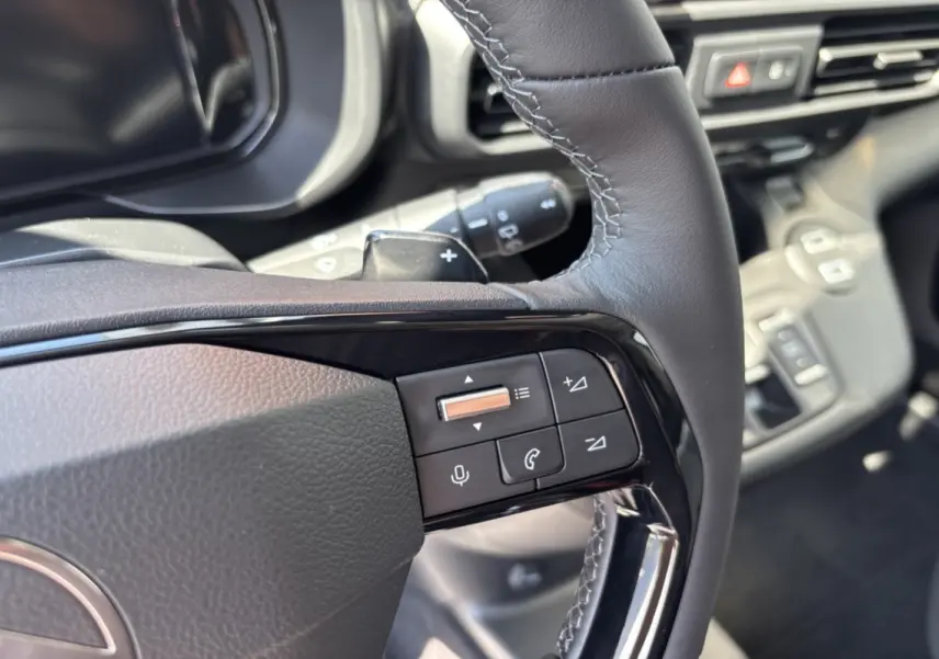 Gros plan sur le volant cuir multifonctions du Citroën Berlingo 2026, boutons de contrôle audio et appel visibles.