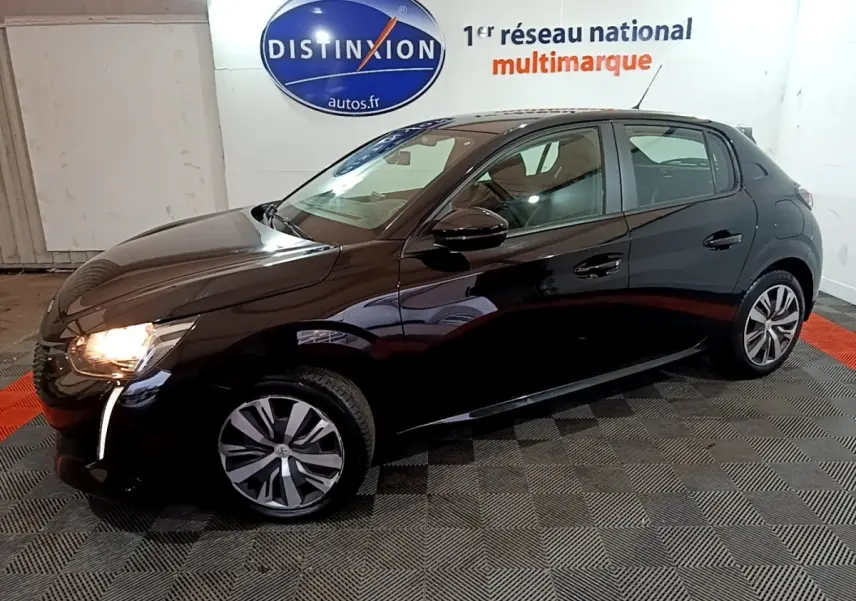 Peugeot 208 noire vue de profil côté gauche, phare avant allumé, dans un showroom intérieur.