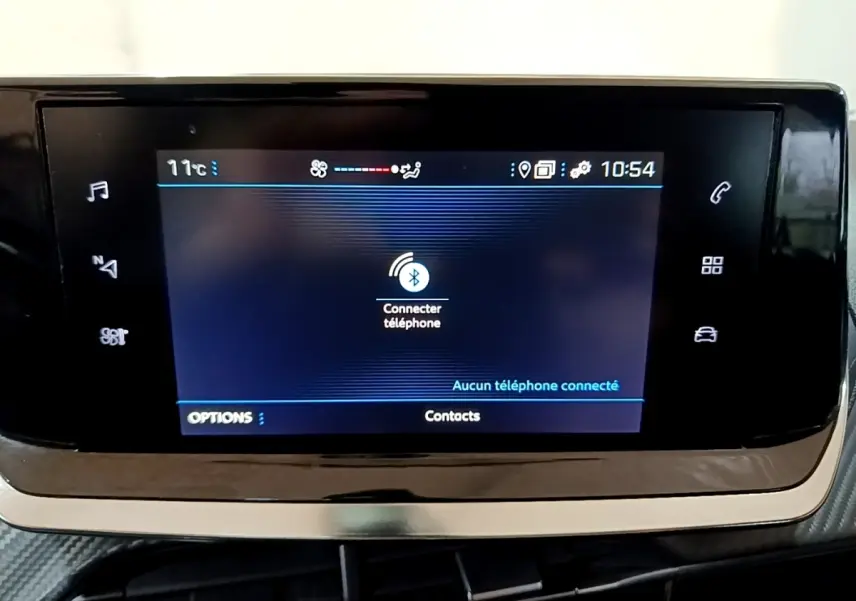 Écran tactile central de la Peugeot 208 noir, affichant la connexion Bluetooth au téléphone, vue de face rapprochée.