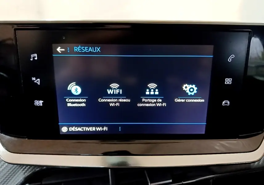 Écran tactile central affichant les options réseau dans l’habitacle d’une Peugeot 208 noire de 2020.