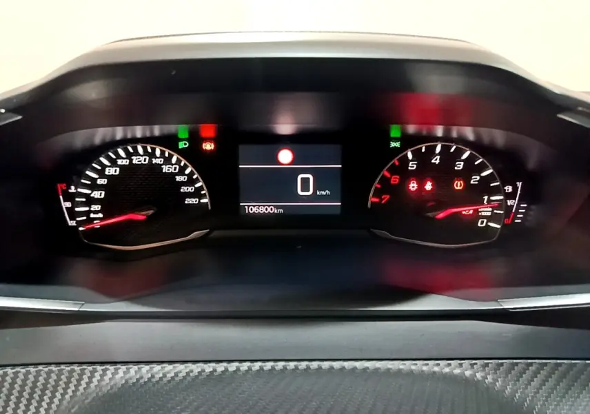 Vue rapprochée du tableau de bord numérique de la Peugeot 208 noir, affichant la vitesse à 0 km/h et le compteur kilométrique.