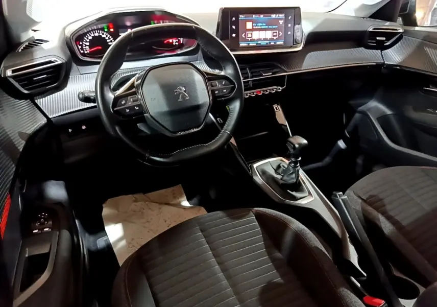 Intérieur de la Peugeot 208 2020 vue de face, volant cuir, tableau de bord avec écran tactile et boîte manuelle.
