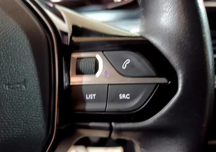 Gros plan sur les commandes du volant cuir noir de la Peugeot 208 BlueHDi 100 S&S Active Business de 2020.