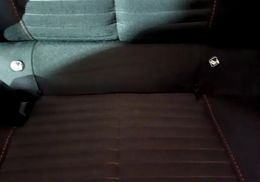 Vue rapprochée de la banquette arrière noire du Peugeot 208 avec logos Isofix visibles sur les côtés.